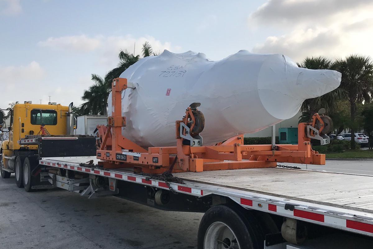 CFM56-3 aircraft engine shrink-wrapped on its transport stand and chained to a flatbed trailer