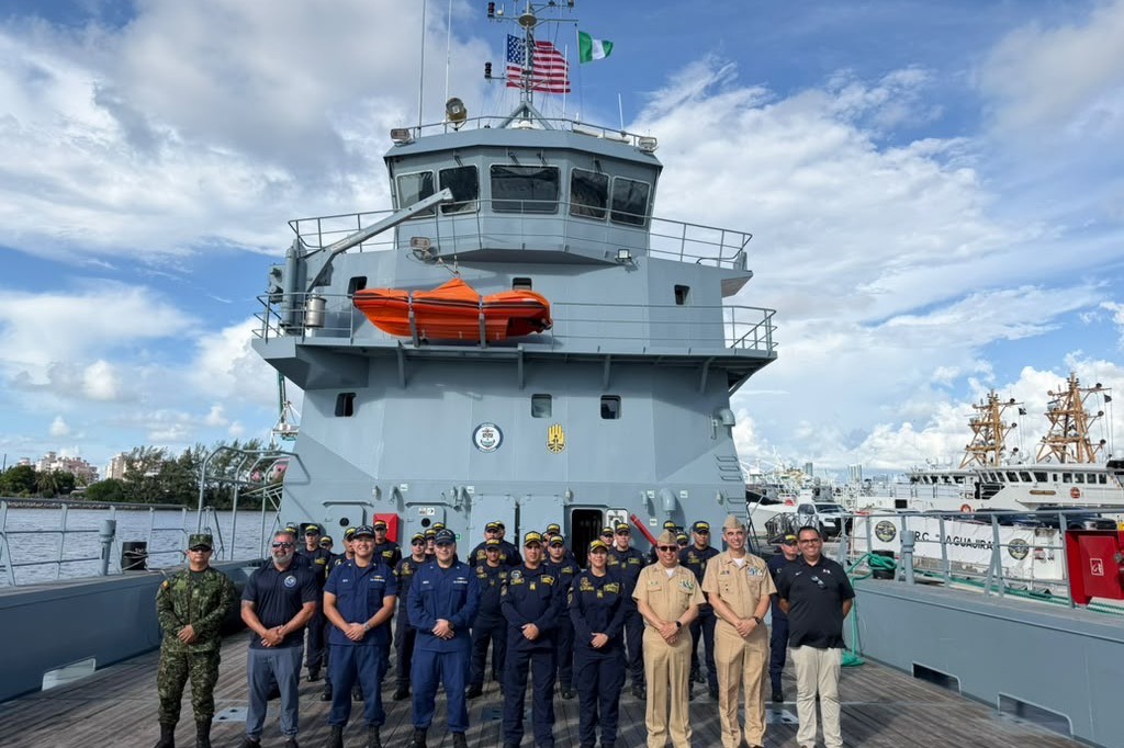 Crew of the Colombian Navy logistics ship ARC La Guajira assembled on deck with U.S. personnel during the vessel's Miami port call, both ensigns flying