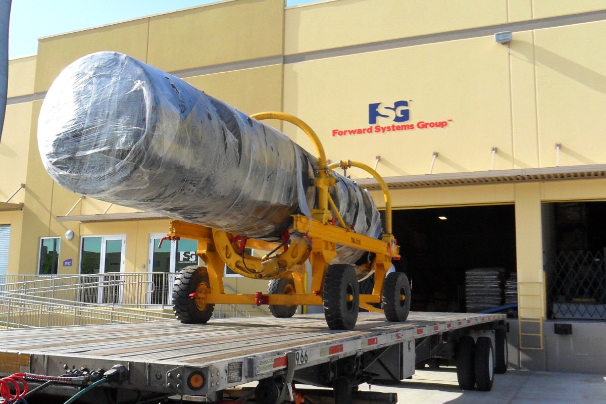 Two KFIR J79 turbojet engines sealed in protective wrapping on a yellow transport cradle, loaded on a flatbed trailer outside the Forward Systems Group facility in Doral, Florida