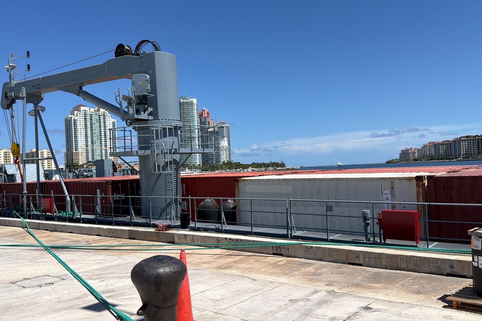 Naval logistics vessel alongside in Miami with containers loaded on deck and its crane rigged for sailing